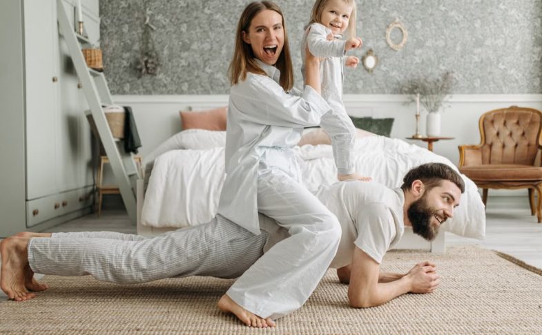 A cheerful family enjoys bonding and playing together on a cozy morning in a stylish bedroom.