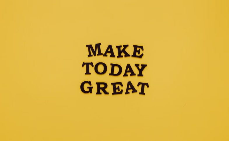 Simple and motivational quote 'Make Today Great' on a minimalist yellow background for inspiration.